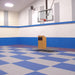 Indoor basketball court featuring blue and grey tiled flooring, with a podium on a raised platform.